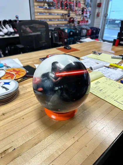 Phone photo of a printed bowling ball on a shop counter, seen from the front